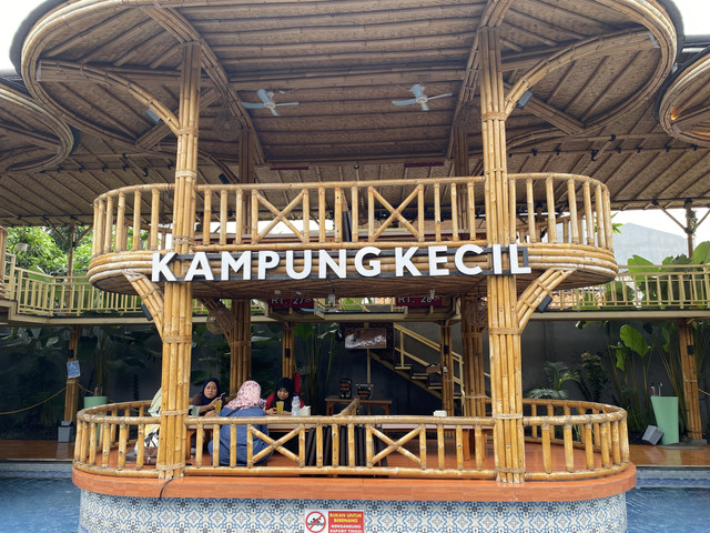 Pengunjung bersantap di salah satu saung Kampung Kecil Senayan, Jakarta. Konsep arsitektur bambu dan area makan di atas kolam menghadirkan suasana yang nyaman untuk berkumpul bersama keluarga maupun teman. Foto: Alya Amelia.