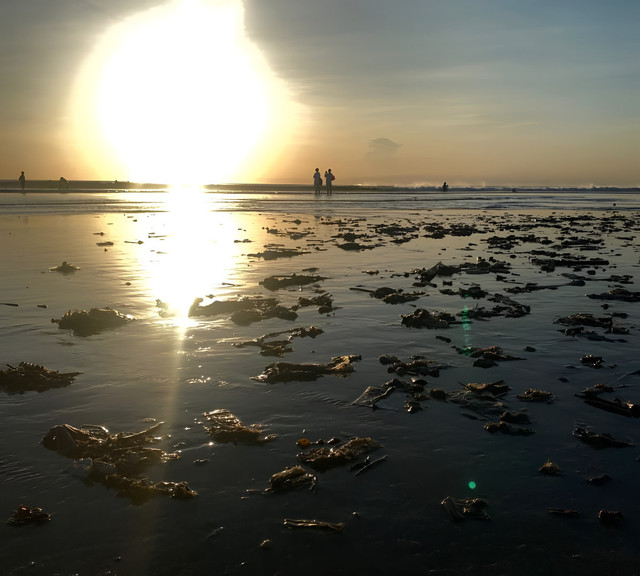 Gambar 1. Tumpukan sampah terlihat di area pesisir Pantai Kuta saat sore hari pada Mei 2026. Di tengah aktivitas wisata dan keindahan matahari terbenam, persoalan sampah plastik masih menjadi tantangan lingkungan yang berulang di kawasan pantai Bali. Sumber: Dokumentasi pribadi penulis (Mei 2026).
