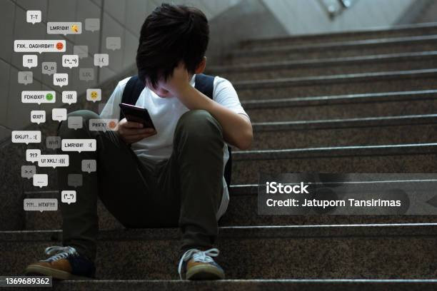 Remaja laki-laki duduk di tangga, menutupi wajahnya dengan tangan (Sumber: iStock)