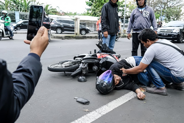 Ilustrasi warga menolong korban kecelakaan, sementara orang lain memilih merekam (AI-generated/ChatGPT)