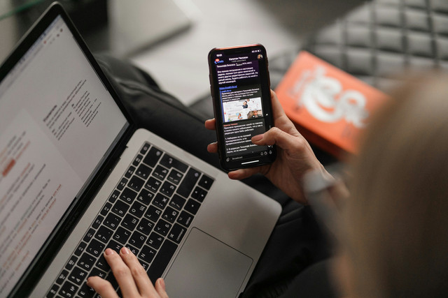 Ilustrasi seseorang menggunakan ponsel dan laptop untuk mengakses informasi di internet. Sumber: Maxim Ilyahov/Unsplash