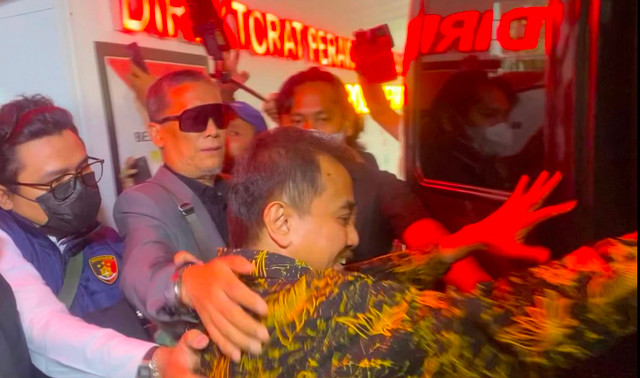 Roy Suryo saat dikawal polisi ke mobil tahanan untuk dibawa ke Kejaksaan Negeri Jakarta Selatan pada Senin (22/6). Foto: Jeni Ritanti/kumparan
