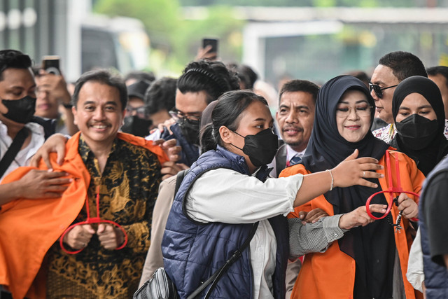 Petugas kepolisian menggiring Roy Suryo (kiri) dan Tifauzia Tyassuma (kanan) ke dalam gedung di Kejaksaan Negeri Jakarta Selatan, Jakarta, Senin (22/6/2026). Foto: Sulthony Hasanuddin/Antara Foto
