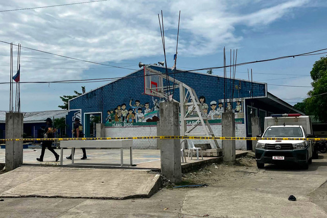 Penyidik kepolisian berada di lokasi kejadian penembakan di kompleks sekolah menengah di Kota Tacloban, Provinsi Leyte, Filipina, pada 22 Juni 2026. Foto: Noel Sianosa / AFP