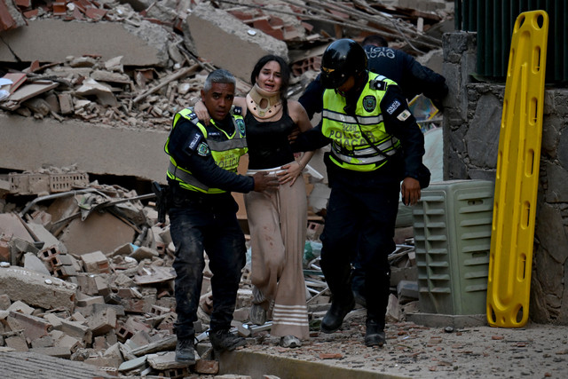 Petugas polisi kota mengevakuasi seorang korban yang terluka dari bangunan yang runtuh setelah gempa bumi melanda Caracas, Venezuela, Rabu (24/6/2026). Foto: Juan Barreto/AFP