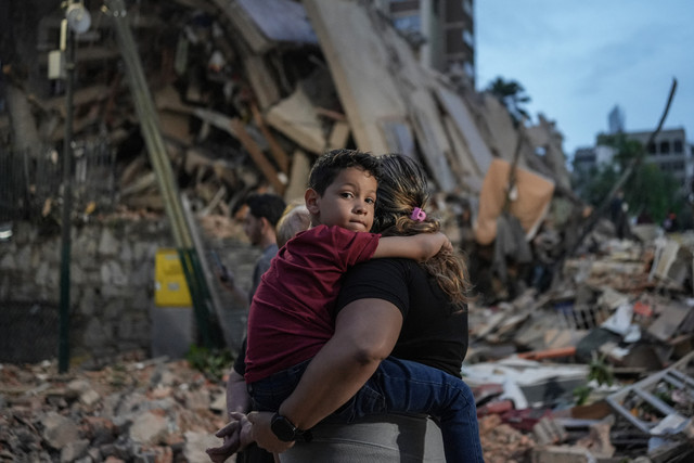 Orang-orang berjalan melewati bangunan yang runtuh setelah gempa bumi di Caracas, Venezuela, Rabu (24/6/2026) waktu setempat. Foto: Manaure Quintero / AFP