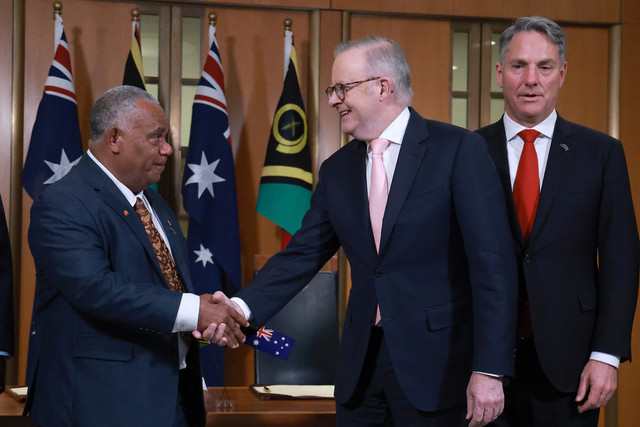Perdana Menteri Vanuatu Jotham Napat (kiri) berjabat tangan dengan Perdana Menteri Australia Anthony Albanese yang disaksikan oleh Menteri Pertahanan Australia Richard Marles (kanan) di Gedung Parlemen di Canberra pada 29 Juni 2026. Foto: David Gray / AFP