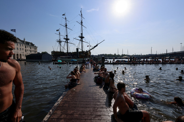 Warga berenang di Marineterrein saat gelombang panas melanda Amsterdam, Belanda, Jumat (26/6/2026). Foto: Nicolas Economou/REUTERS