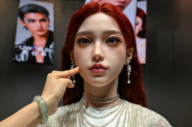Seorang wanita menyentuh wajah sebuah robot humanoid saat peluncuran robot humanoid U1 yang diproduksi oleh UWORLD, sebuah merek di bawah UBTECH Robotics, di Shenzhen, provinsi Guangdong, China, Selasa (30/6/2026). Foto: Adek Berry/AFP