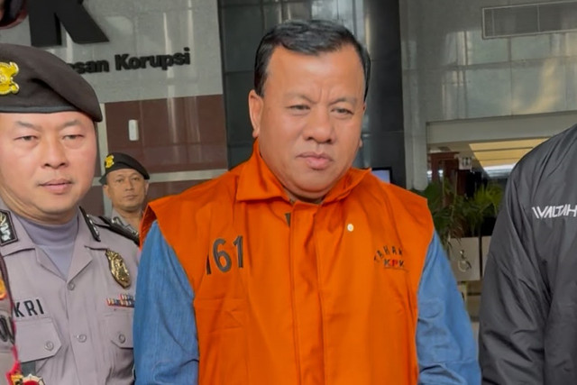 Bupati Kuantan Singingi (Kuansing) Suhardiman Amby mengenakan rompi tahanan berjalan menuju mobil tahanan usai menjalani pemeriksaan di Gedung Merah Putih KPK, Jakarta, Rabu (1/7/2026). Foto: Kevin Daniel/kumparan