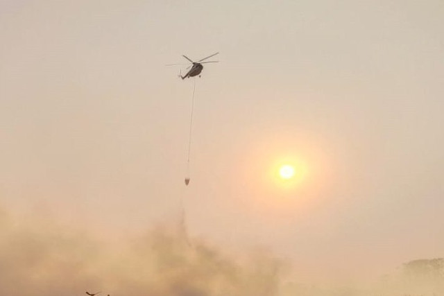 Dua unit helikopter berusaha memadamkan api di Tempat Pembuangan Akhir (TPA) Jatiwaringin, Kabupaten Tangerang, Banten, Rabu (1/7/2026). Foto: kumparan