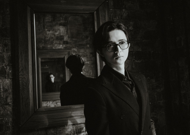 Andy Lee/Pexels (https://www.pexels.com/photo/moody-portrait-of-man-with-glasses-and-mirror-reflection-34219365/)