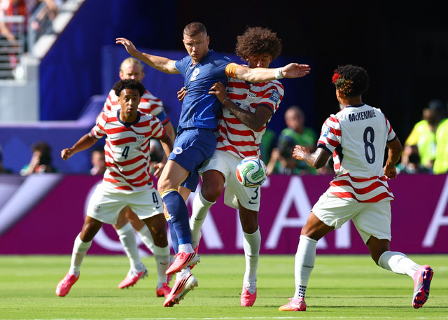Penyerang timnas Bosnia dan Herzegovina, Edin Dzeko, berduel berebut bola dengan bek Amerika Serikat, Chris Richards, dalam pertandingan babak 32 besar Piala Dunia 2026 di Stadion San Francisco Bay Area, Santa Clara, California, Rabu (1/7/2026). Foto: Phil Noble/REUTERS