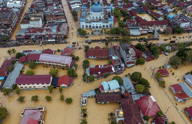 Warga bersama anaknya berusaha melintasi banjir dengan menggunakan perahu di Lhoksukon, Aceh Utara, Aceh Kamis (6/10/2022). (ANTARA FOTO/Rahmad)Foto udara memperlihatkan kawasan yang terendam banjir di Lhoksukon, Aceh Utara, Aceh, Kamis (6/10/2022). Badan Penanggulangan Bencana Aceh (BPBA) menyebutkan banjir akibat hujan deras dalam dua hari terakhir tersebut merendam 12 kecamatan di Aceh Utara. (Zikri Maulana/AFP/Getty Images)