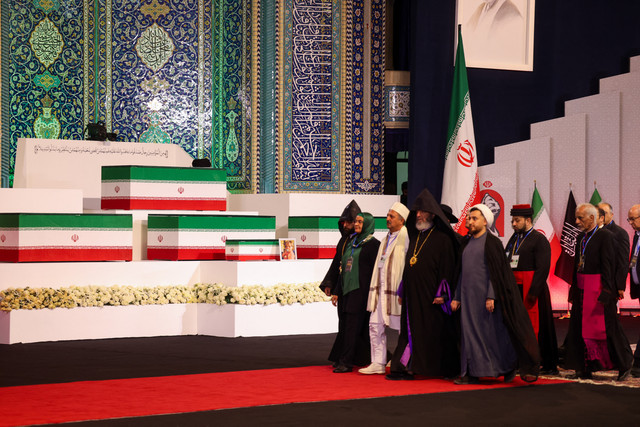 Pejabat lokal dan asing berjalan melewati peti mati mendiang pemimpin tertinggi Iran, Ali Khamenei, beserta anggota keluarganya setelah memberikan penghormatan terakhir di Grand Mosalla di Teheran, Jumat (3/7/2026). Foto: Atta Kenare/AFP
