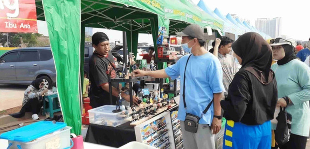 Ilustrasi: Pelaku UMKM melayani pelanggan di tengah tantangan perubahan iklim yang memengaruhi aktivitas usaha. Sumber: Shutterstock