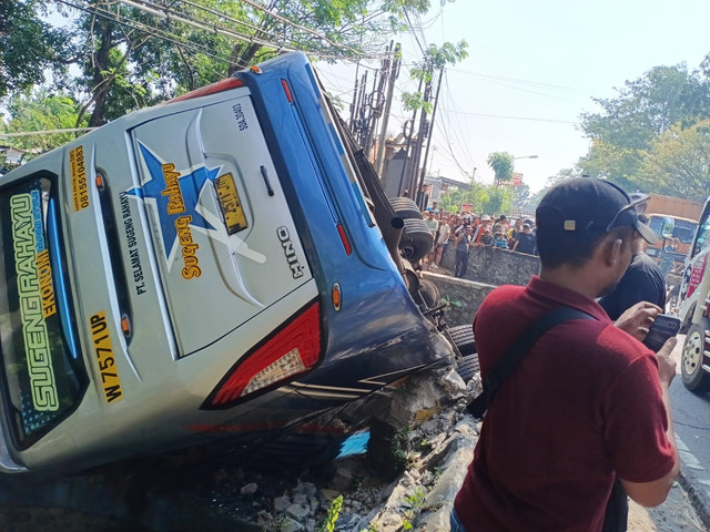 Bus Sugeng Rahayu terjun ke sungai di Kabupaten Nganjuk, Jawa Timur setelah terlibat kecelakaan dengan sebuah dump truk pada Sabtu (4/7). Dok: Polres Nganjuk.