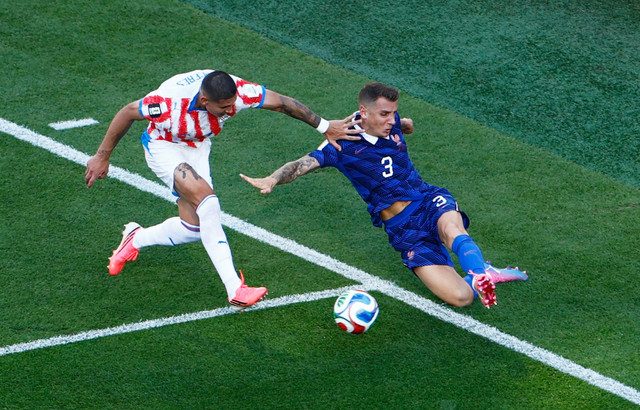 Juan Jose Caceres dari Paraguay beraksi dengan Lucas Digne dari Prancis pada pertandingan Piala Dunia FIFA 2026 antara Paraguay vs Prancis di Stadion Philadelphia, Philadelphia, Pennsylvania, AS, Minggu (5/7/2026) dini hari WIB. Foto: Jeenah Moon/REUTERS