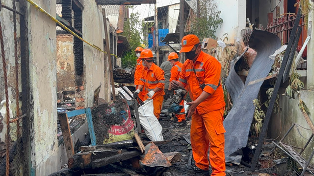 Petugas membersihkan lokasi kebakaran yang menewaskan seorang lansia di Jalan Palmerah Utara III, Jakarta Barat. Senin (6/7). Foto: Pradya Tirta/kumparan