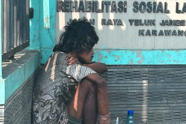 Pria diduga orang dengan gangguan jiwa (ODGJ) duduk di depan UPTD Panti Sosial Rehabilitasi Lanjut Usia Karawang milik Dinsos Jawa Barat (Jabar) di Karawang, Minggu (5/7/2026). Foto: Dok. Istimewa