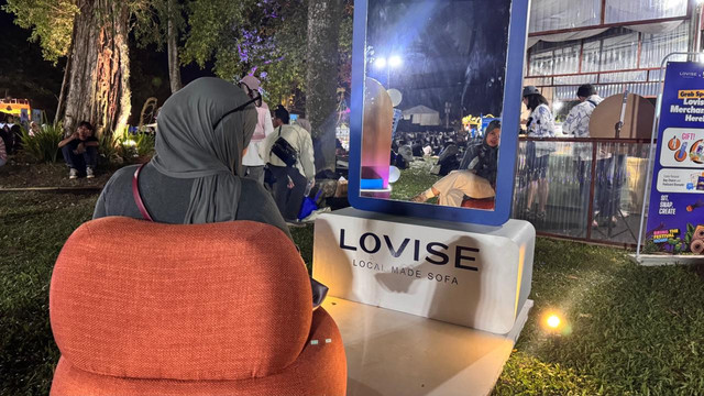 Pengunjung memanfaatkan area duduk di booth Lovise Sofa untuk melepas penat di sela menikmati rangkaian Prambanan Jazz Festival 2026. Foto: Pandangan Jogja