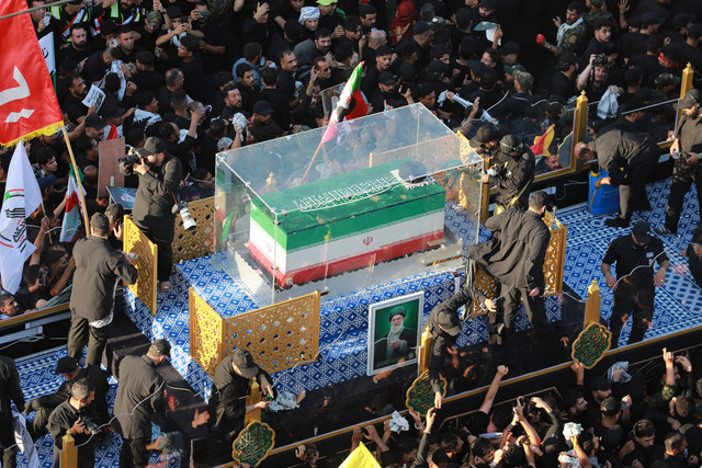 Kerumunan pelayat mengelilingi iring-iringan yang membawa peti jenazah pemimpin tertinggi Iran yang terbunuh, Ali Khamenei, selama prosesi pemakaman di Najaf pada 8 Juli 2026. Foto: Murtaja LATEEF / AFP