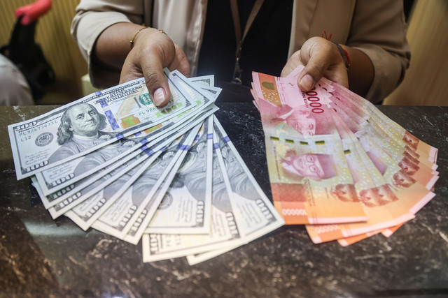 Karyawan menunjukkan uang pecahan rupiah dan dolar Amerika Serikat (AS) di gerai penukaran uang asing Dolarasia Money Changer Cibubur, di Jatisampurna, Bekasi, Jawa Barat, Kamis (9/7/2026). Foto: ANTARA FOTO/Darryl Ramadhan