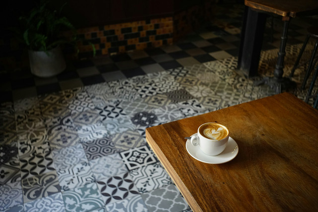 Ilustrasi secangkir kopi yang tergeletak di atas meja. Foto: Nam Quach/Unsplash