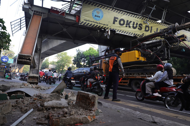 Kondisi jembatan penyeberangan orang (JPO) di Jalan Kapten Tendean, Jakarta, nyaris roboh setelah tertabrak truk bermuatan alat berat, Selasa (14/7/2026). Salah satu tiang penyangga JPO bergeser sekitar tiga meter akibat benturan tersebut. Foto: Jamal Ramadhan/kumparan