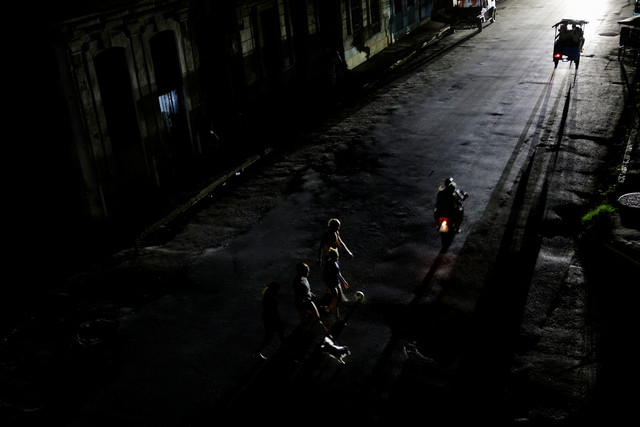 Orang-orang menyeberang jalan saat jaringan listrik nasional Kuba runtuh, menandai pemadaman besar ketiga dalam sembilan hari, di Havana, Kuba, 14 Juli 2026. Foto: REUTERS/Norlys Perez