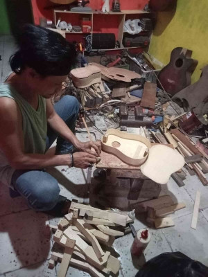 Pengrajin bernama We'ong saat menyelesaikan pembuatan ukulele di bengkel kerjanya di Desa Penaruban, Kecamatan Kaligondang. Foto dokumen pribadi.