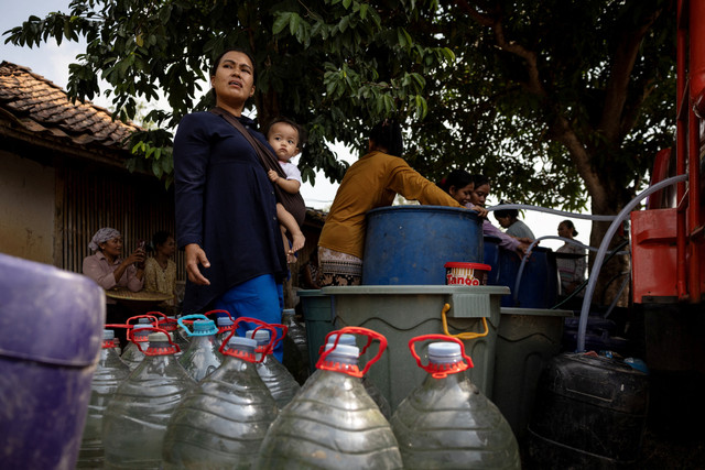 Sejumlah warga mengumpulkan bantuan air bersih gratis dari BPBD di wilayah yang dilanda kekeringan saat musim kemarau, di tengah ancaman fenomena El Nino, di desa Rido Galuh, Kabupaten Bekasi, Indonesia, Kamis (16/7/2026). Foto: Willy Kurniawan/REUTERS