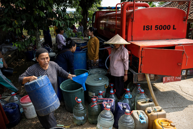 Sejumlah warga mengumpulkan bantuan air bersih gratis dari BPBD di wilayah yang dilanda kekeringan saat musim kemarau, di tengah ancaman fenomena El Nino, di desa Rido Galuh, Kabupaten Bekasi, Indonesia, Kamis (16/7/2026). Foto: Willy Kurniawan/REUTERS