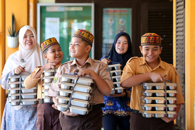 Pelajar bersama petugas SPPG Ie Masen Ulee Kareng dan guru membawa paket Makan Bergizi Gratis (MBG) untuk dibagikan kepada peserta Masa Pengenalan Lingkungan Sekolah (MPLS) di SD Negeri 11 Banda Aceh, Aceh, Jumat (17/7/2026). Foto: Irwansyah Putra/ANTARA FOTO