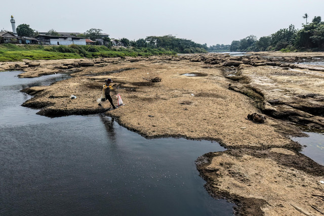 Seorang nelayan mencari ikan dengan jaring di sungai di Tangerang, provinsi Banten, pada 17 Juli 2026, saat permukaan air menurun sebagian akibat dampak El Nino, yang telah membawa musim kemarau berkepanjangan. Foto: Bay Ismoyo/AFP