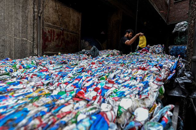 Seorang pekerja Mesir menyiapkan plastik untuk diproses di pabrik daur ulang di kota sampah di lingkungan Manshiyet Nasser di Kairo, Mesir (6/7/2026). Foto: Khaled Desouki/AFP