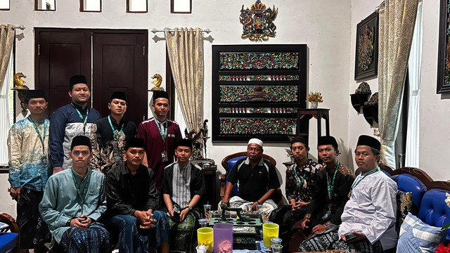 Mahasiswa P2M Universitas Al-Amien Prenduan Kelompok VI berfoto bersama pengrajin ukir Slamet Riyadi di kediamannya yang dipenuhi berbagai karya ukiran kayu khas Desa Karduluk, Sumenep.