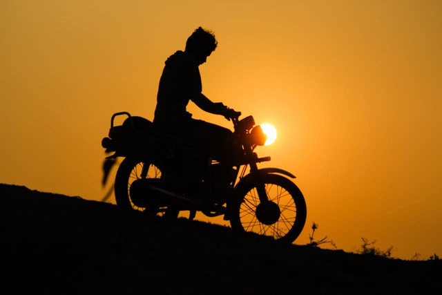 Ilustrasi : Seorang pengendara motor melakukan perjalanan jauh hingga menatap senja. Foto : vr visualrepo/pexels