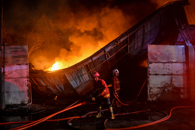 Petugas pemadam kebakaran menyemprotkan air ke arah api yang membakar pabrik dupa di Periuk, Kota Tangerang, Banten, Senin (20/7/2026). Foto: Putra M. Akbar/ANTARA FOTO