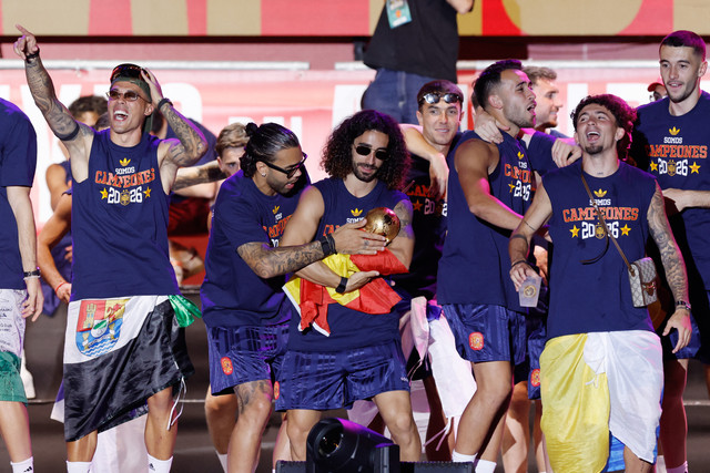 Bek tim nasional Spanyol, Marc Cucurella (tengah), memeluk trofi saat para pemain merayakan kemenangan di atas panggung di Plaza de Cibeles, Madrid, Spanyol, Senin (20/7/2026). Foto: Oscar Del Pozo/AFP