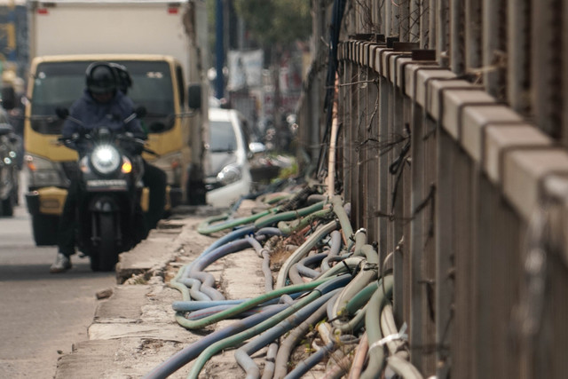 Kabel utilitas menjuntai di sepanjang trotoar Jalan Jembatan Caman Raya, Bekasi, Selasa (21/7/2026). Foto: Iqbal Firdaus/kumparan