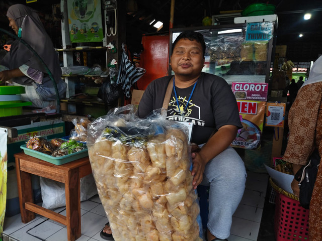 pGilang Rizki (29) difabel tunanetra lulusan UIN Sunan Kalijaga berjualan kerupuk rambat karena sudahnya cari pekerjaan kantoran. Menjadi pedagang asongan juga penuh rintangan bagi pria kelahiran Brebes, Jawa Tengah itu, Rabu (22/7/2026). Foto: Arfiansyah Panji Purnandaru/kumparan