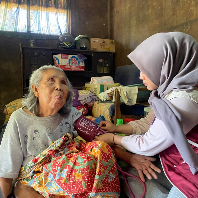 Mahasiswa KKN UPI Sumedang Kelompok 4 melakukan pemeriksaan tekanan darah door to door di rumah salah satu warga lansia Desa Cilopang