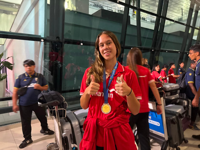 Pemain Timnas Wanita Indonesia, Emily Nahon, memamerkan medali juara AFF Women's Cup 2026 di Bandara Internasional Soekarno-Hatta, Kamis (23/7). Foto: Antika Fahira/kumparan
