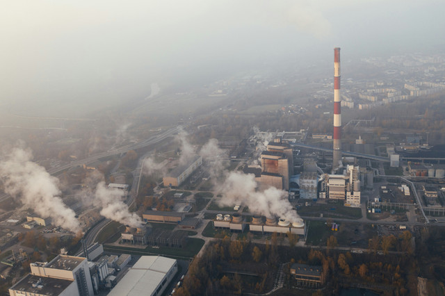 Ilustrasi kawasan industri dengan cerobong asap yang mengeluarkan emisi karbon, yang menggambarkan sektor padat karbon yang menjadi target kebijakan CBAM Uni Eropa. Foto: Marcin Jozwiak. Sumber: Unsplash.