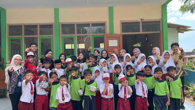 Mahasiswa KKN Kolaboratif UNEJ-UNARS berfoto bersama seluruh siswa SD Negeri 01 Baderan dalam rangkaian program HEBAT.
