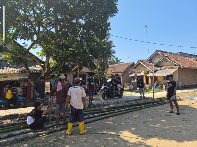 Anggota laki-laki kelompok 8 dan beberapa pemuda Kp. Cibogo bersinergi merenovasi lapangan voli Kp. Cibogo 