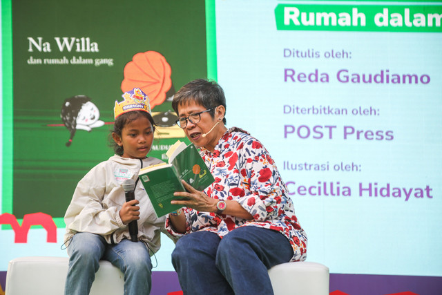 Reda Gaudiamo membaca buku dengan salah satu anak yang hadir di kumparanMOM Festival Hari Anak. Foto: dok. kumparan