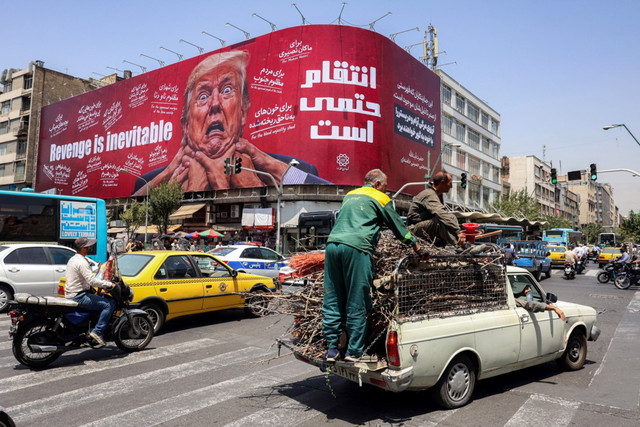 Para pengendara mobil melintas di depan papan reklame besar yang menjanjikan pembalasan terhadap Presiden AS Donald Trump di sepanjang Jalan Jomhouri di pusat Teheran, Iran, Senin (27/7/2026). Foto: AFP