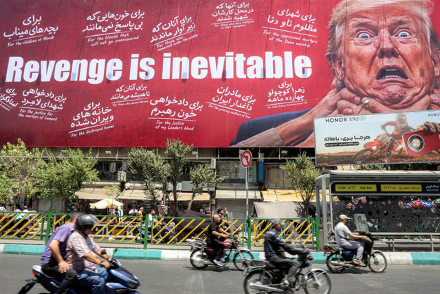 Para pengendara mobil melintas di depan papan reklame besar yang menjanjikan pembalasan terhadap Presiden AS Donald Trump di sepanjang Jalan Jomhouri di pusat Teheran, Iran, Senin (27/7/2026). Foto: AFP